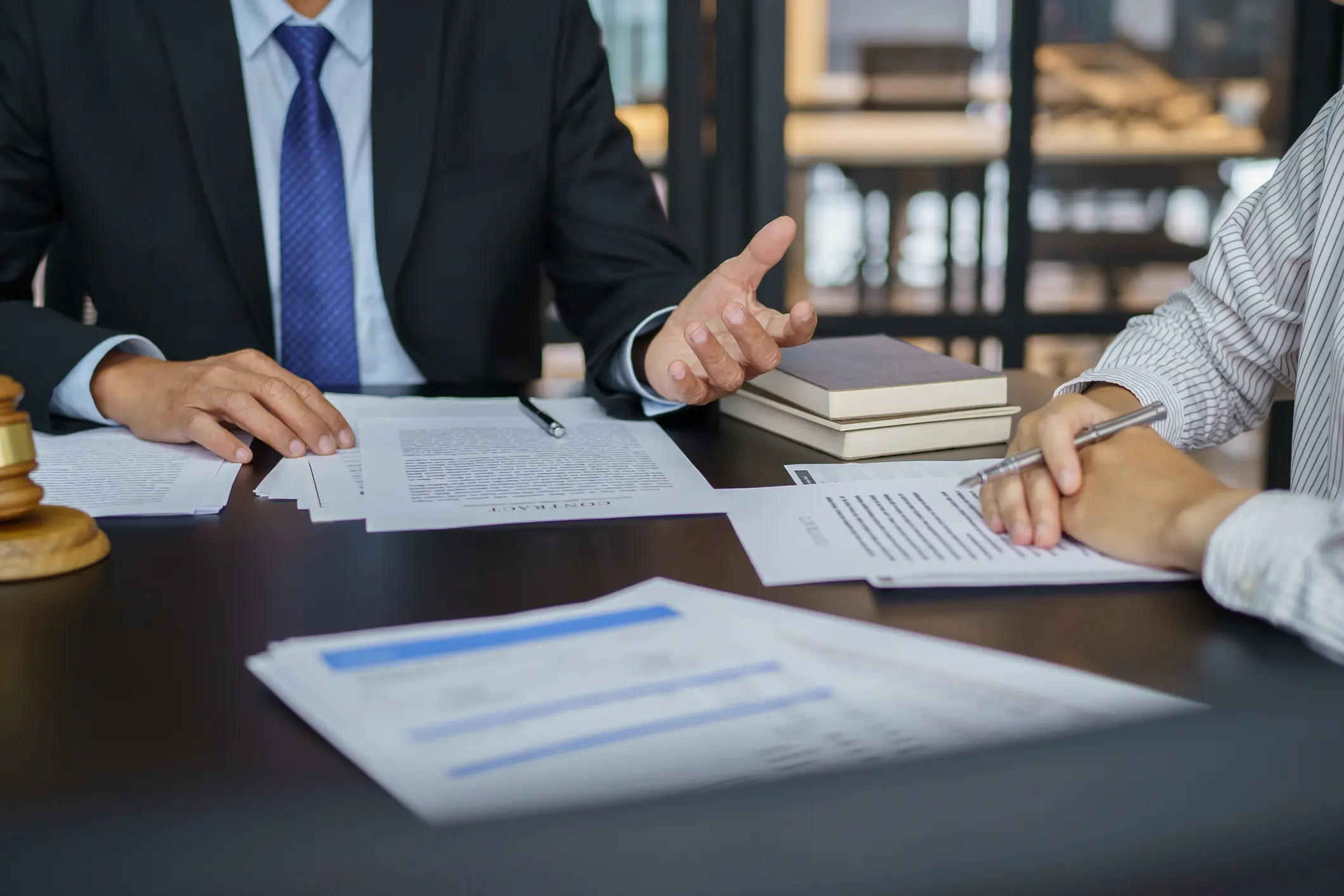 Two professionals discussing documents in a business meeting.