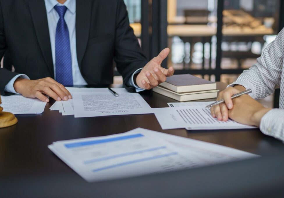 Two professionals discussing documents in a business meeting.